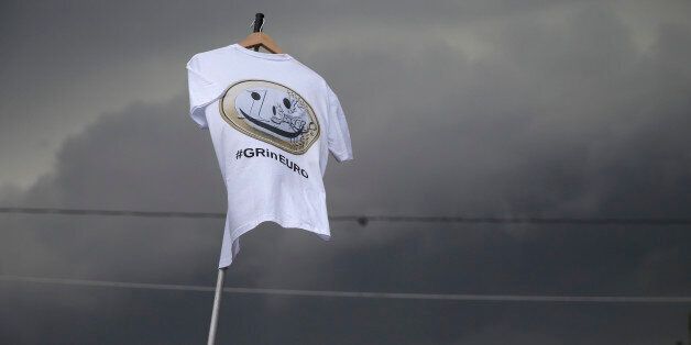 Dark clouds fill the sky as a Pro-Euro protestor holds a T-shirt with a hashtag
