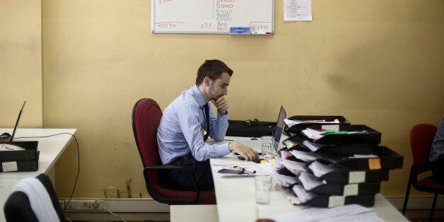 A financial trader works at his desk as trading on the Greek stock exchange halts in the offices of the Nuntius Securities SA broking firm in Athens, Greece, on Monday, June 29, 2015. Greece shut its banks and imposed capital controls in an announcement designed to avert the collapse of its financial system, heightening the risk it will be forced out of the euro. Photographer: Simon Dawson/Bloomberg via Getty Images