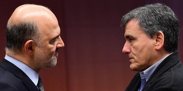 Greece's Finance Minister Euclid Tsakalotos (R) and European Commissioner for Economic and Financial Affairs, Taxation and Customs Pierre Moscovici speak together ahead of a Eurogroup finance ministers meeting at the European Council in Brussels, on December 5, 2016. / AFP / EMMANUEL DUNAND (Photo credit should read EMMANUEL DUNAND/AFP/Getty Images)