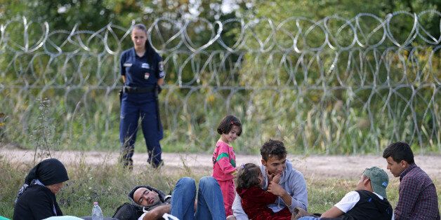 Migrants sit on the field as they were stopped by the Hungarian police after illegally crossing from Serbia to Hungary near the village of Asttohatolom, Hungary, September 16, 2015. Hungary's right-wing government shut the main land route for migrants into the European Union on Tuesday, taking matters into its own hands to halt Europe's influx of refugees. REUTERS/Dado Ruvic