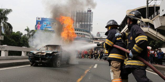 MAKATI CITY, June 22, 2016-- Firefighters put out a fire of a burning car during the 2nd National Simultaneous Earthquake Drill in Makati City, the Philippines, June 22, 2016. (Xinhua/Rouelle Umali via Getty Images)