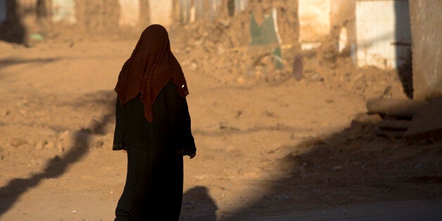 KASHGAR, CHINA - SEPTEMBER 21: Woman passing by demolished houses, Old town of Kashgar, Xinjiang Uyghur Autonomous Region, China on September 21, 2012 in Kashgar, China. (Photo by Eric Lafforgue/Art in All of Us/Corbis via Getty Images)