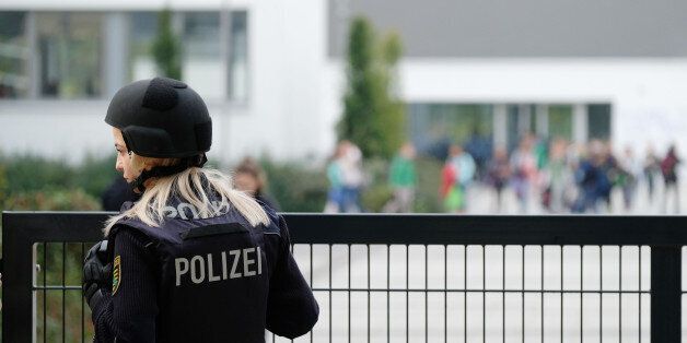 A police woman stands in front of a grammar school in Leipzig, eastern Germany, on October 17, 2016.Several schools across Germany were being searched after they received threats by email Monday, police said, although officials did not believe that the letters constituted a serious danger. / AFP / dpa / Sebastian Willnow / Germany OUT (Photo credit should read SEBASTIAN WILLNOW/AFP/Getty Images)
