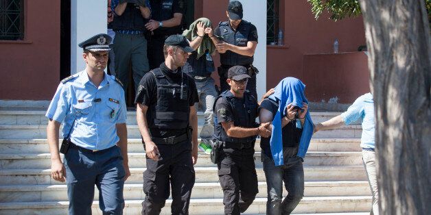 A Greek police officer escorts a Turkish officer who fled to Greece by helicopter after last week's failed coup, as he leaves the courthouse of Alexandroupoli, near the Greek-Turkish border, on July 21, 2016. A Greek court on July 21 sentenced eight Turkish military officers who fled last week's failed coup to suspended two-month prison terms, an AFP reporter said. The officers, sought by Turkey to face a military trial at home, have requested asylum in Greece and will remain in police custody u