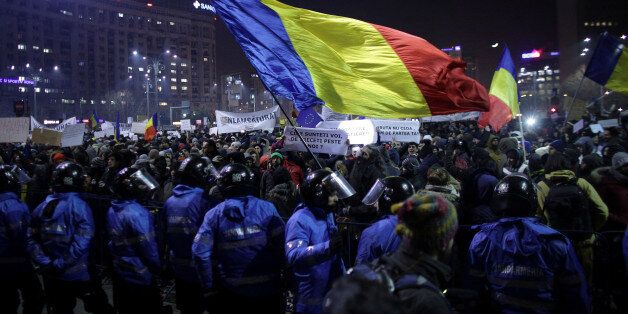 Protesters wave a Romanian flag during a demonstration in Bucharest, Romania, February 1, 2017. Inquam Photos/Octav Ganea via REUTERS ATTENTION EDITORS - THIS IMAGE WAS PROVIDED BY A THIRD PARTY. EDITORIAL USE ONLY. ROMANIA OUT. NO COMMERCIAL OR EDITORIAL SALES IN ROMANIA.