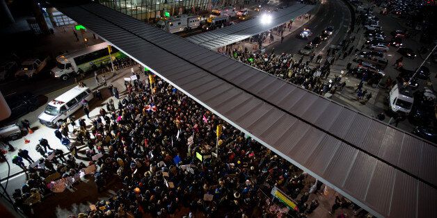 Demonstrators gather outside John F. Kennedy International Airport (JFK) to protest U.S. President Donald Trump's executive order blocking visitors from seven predominantly Muslim nations in New York, U.S., on Saturday, Jan. 28, 2017. A U.S judge temporarily blocked the Trump administration from enforcing an executive order that would have led to the deportation of refugees and visa-holders from seven mostly Muslim countries. Photographer: Michael Nagle/Bloomberg via Getty Images