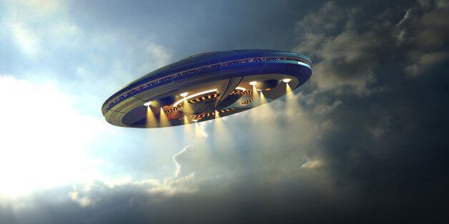 Alien UFO saucer flying on a clouds background above Earth
