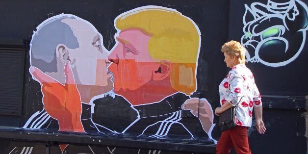 A woman walks past a mural on a restaurant wall depicting US Presidential hopeful Donald Trump and Russian President Vladimir Putin greeting each other with a kiss in the Lithuanian capital Vilnius on May 13, 2016.Kestutis Girnius, associate professor of the Institute of International Relations and Political Science in Vilnius university, told AFP -This graffiti expresses the fear of some Lithuanians that Donald Trump is likely to kowtow to Vladimir Putin and be indifferent to Lithuanias security concerns. Trump has notoriously stated that Putin is a strong leader, and that NATO is obsolete and expensive. / AFP / Petras Malukas (Photo credit should read PETRAS MALUKAS/AFP/Getty Images)