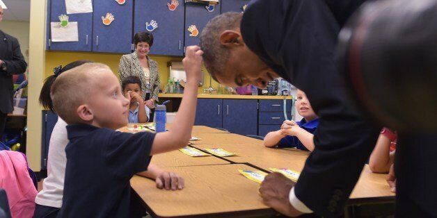 US President Barack Obama offers leans over for a boy to feel his hair during a visit to an elementary school at MacDill Air Force Base in Tampa, Florida on September 17, 2014. AFP PHOTO/Mandel NGAN (Photo credit should read MANDEL NGAN/AFP/Getty Images)