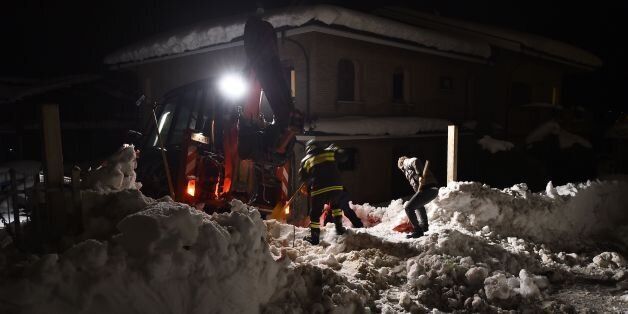 Rescuers remove snow next to a house on a road to the village of Penne, after an avalanche engulfed the mountain hotel Rigopiano in Farindola in earthquake-ravaged central Italy, on January 19, 2017.At least 25 people, including several children, were feared dead after a barrage of snow hit the Hotel Rigopiano on Wednesday afternoon, ripping the three-storey building from its foundations and moving it ten metres (11 yards). / AFP / FILIPPO MONTEFORTE (Photo credit should read FILIPPO MONT