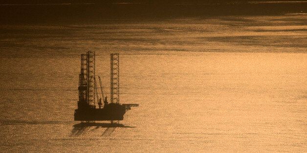 A picture taken on January 13, 2017 shows an off-shore oil rig, off the coast of Port-Gentil at sunrise. / AFP / Justin TALLIS (Photo credit should read JUSTIN TALLIS/AFP/Getty Images)