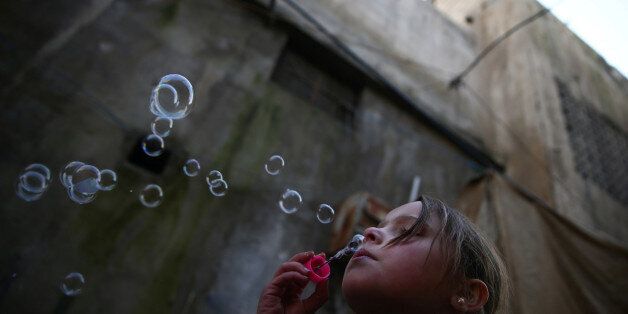 A girl blows bubbles in the rebel held besieged city of Douma, in the eastern Damascus suburb of Ghouta, Syria January 19, 2017. REUTERS/Bassam Khabieh