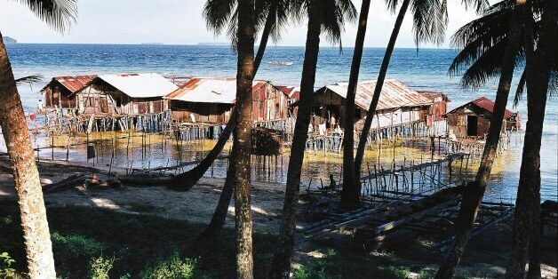 PAPUA NEW GUINEA - FEBRUARY 9: Palm trees and pile dwellings, Biak island, Papua New Guinea. (Photo by DeAgostini/Getty Images)