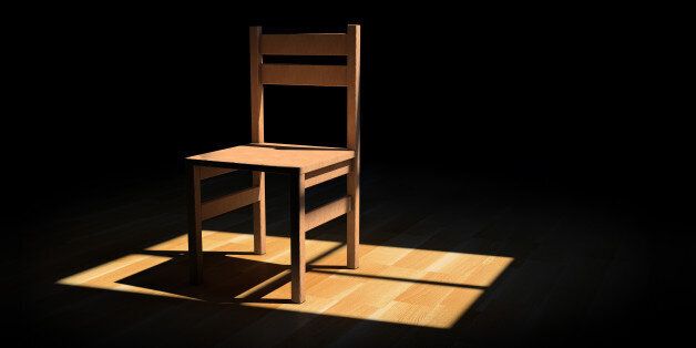 Chair on a dark room illuminated only by a light coming from a window