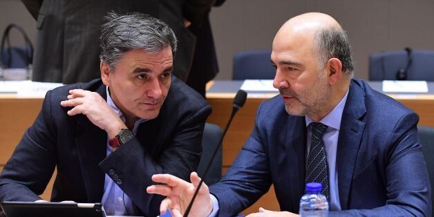 Greece's Finance Minister Euclid Tsakalotos (L) and European Commissioner for Economic and Financial Affairs, Taxation and Customs Pierre Moscovici take part in an Economic and Financial (ECOFIN) Affairs Council meeting at the European Council, in Brussels, on January 27, 2017. / AFP / EMMANUEL DUNAND (Photo credit should read EMMANUEL DUNAND/AFP/Getty Images)
