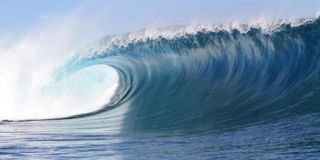 incredibly big wave breaking onto shallow reef in tropical Fiji