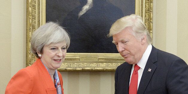 U.S. President Donald Trump, right, stands for a photograph with Theresa May, U.K. prime minister, in the Oval Office of the White House in Washington, D.C., U.S., on Friday, Jan. 27, 2017. The British prime minister is planning to pitch a free-trade deal to the new U.S. leader just as the reality of a new era of protection for American workers sinks in. Photographer: Olivier Douliery/Pool via Bloomberg