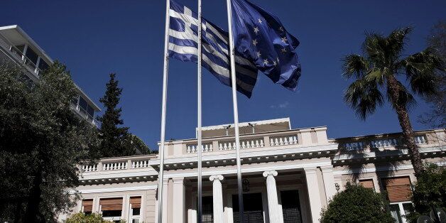 A Greek national flag and a European Union flag flutter outside the Maximos mansion as a government council at the Prime Minister's office takes place, in Athens May 13, 2015. Greece's government on Wednesday ruled out rushing to a referendum to secure public support for unpopular reforms, opting instead to make a final push for a compromise with lenders by the end of the month. REUTERS/Alkis Konstantinidis