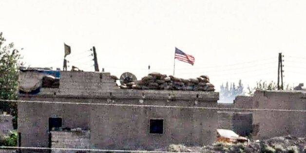 A picture taken from the Turkish side of the Syrian border in the Turkish town of Akcakale, in Sanliurfa, shows a US flag at the People's Protection Units (YPG) position in the Syrian city of Tal-Abyad, on September 16, 2016. The UN Security Council will hold an urgent meeting on September 17, 2016 to hear details of a US-Russian deal on Syria as it weighs whether to endorse the agreement, diplomats said. / AFP / STRINGER (Photo credit should read STRINGER/AFP/Getty Images)