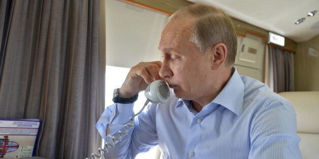 Russian President Vladimir Putin speaks on the phone while inspecting the area, damaged by wildfires in spring 2015, onboard a helicopter in Khakassia region, Russia, June 26, 2015. REUTERS/Alexei Druzhinin/RIA Novosti/Kremlin ATTENTION EDITORS - THIS IMAGE HAS BEEN SUPPLIED BY A THIRD PARTY. IT IS DISTRIBUTED, EXACTLY AS RECEIVED BY REUTERS, AS A SERVICE TO CLIENTS.