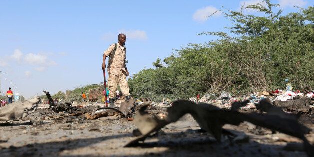A Somali soldier inspects the scene of an explosion where a general and at least seven of his bodyguards were killed after their vehicle was rammed by a car bomb driven by an al Shabaab suicide attacker, in Somalia's capital Mogadishu, September 18, 2016. REUTERS/Feisal Omar