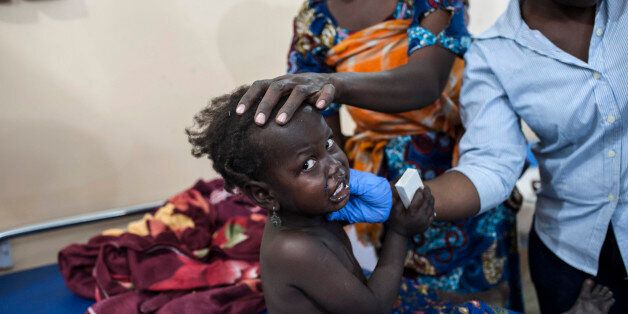 A mother and nursing staff tend to a young girl at the Maiduguri State Specialist Hospital on January 18, 2017. At least 70 people have died in an Internally Displace Camp in Borno State from an accidental military airstrike on January 17, 2017, intended to target Boko Haram militants in Rann, in north-eastern Nigeria. / AFP / STEFAN HEUNIS (Photo credit should read STEFAN HEUNIS/AFP/Getty Images)