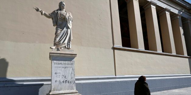 A woman walks past the statue of Rigas Feraios, a hero of Greece's War of Independence against centuries of Ottoman rule in 1821, at Athens University, February 20, 2015. Greece and the euro zone are close to a deal on a financing-for-reforms package, a senior Greek official said ahead of a crucial meeting of euro zone finance ministers later on Friday. REUTERS/Alkis Konstantinidis (GREECE - Tags: POLITICS BUSINESS)