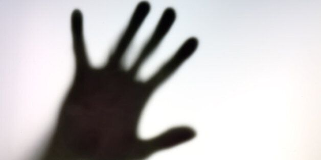Silhouette of hand on a white surface.