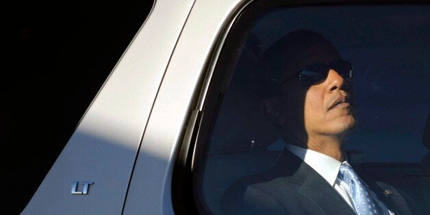 Following his late night rally with President Clinton, Obama dozes behind dark sunglasses.