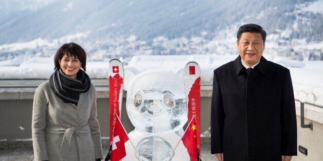 Swiss Federal President Doris Leuthard (L) and China's President Xi Jinping (R) pose next to a panda ice sculpture as they launch the Swiss-Sino year of tourism , on January 17, 2017 on the sideline of the 47th annual meeting of the World Economic Forum, in Davos. / AFP / POOL / LAURENT GILLIERON (Photo credit should read LAURENT GILLIERON/AFP/Getty Images)