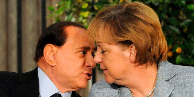 Italy's Prime Minister Silvio Berlusconi (L) speaks to German Chancellor Angela Merkel during a joint news conference with fellow European leaders at the residence of Israel's Prime Minsiter Ehud Olmert in Jerusalem January 18, 2009. Picture taken January 18, 2009. REUTERS/Ammar Abd Rabbo/Pool (JERUSALEM)