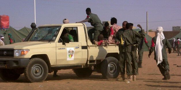 EDITORS NOTE: Graphic content / Soldiers gather at a pickup truck following a suicide bomb attack that ripped through a camp grouping former rebels and pro-government militia in Gao, in the troubled northern Mali left 50 people dead on January 18, 2017 in Gao.Malian president's office ordered three days of national mourning following the attack, the worst in the country in recent years. / AFP / STRINGER (Photo credit should read STRINGER/AFP/Getty Images)