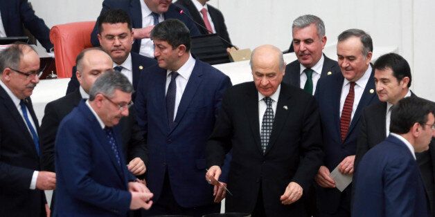 Turkey's Nationalist Movement Party's leader (MHP) Devlet Bahceli (C) casts his vote for the first article during the second tour debating a reform of the constitution, at the Turkish parliament in Ankara on January 18, 2017.The parliament backed the two final sections of the 18-article new constitution late January 15 after a marathon week of debating that began on January 9 and included sessions that often lasted late into the night. The ruling Justice and Development Party (AKP) mustered the necessary 330 or more votes -- a three-fifths majority -- needed to adopt the constitutional change and send it to a referendum for final approval. The constitution plan now go to a second reading in the Ankara parliament where the 18 articles will again be debated one by one. / AFP / Adem ALTAN (Photo credit should read ADEM ALTAN/AFP/Getty Images)