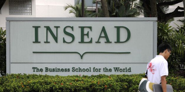 A student walks past a sign for the Asia campus of Insead in Singapore, on Monday, Dec. 6, 2010. Yale University may join Duke University, the University of Chicago, Imperial College London and France's Insead among colleges to set up a campus in Singapore, a nation of 5 million people with a land mass smaller than New York City. The city-state wants to attract 150,000 international students by 2015 as it seeks to boost the contribution education makes to gross domestic product to 5 percent from 3.2 percent last year and 1.9 percent in 2000. Photographer: Munshi Ahmed/Bloomberg via Getty Images