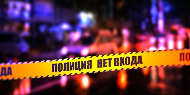 A night time street scene with focus on safety Police tape in Russian 'Police No Entry'.