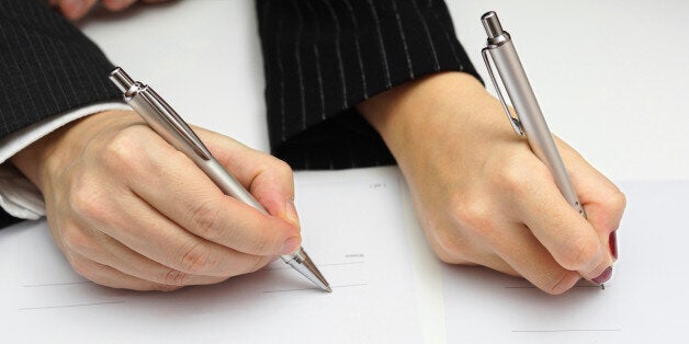 man and woman signing document or prenup