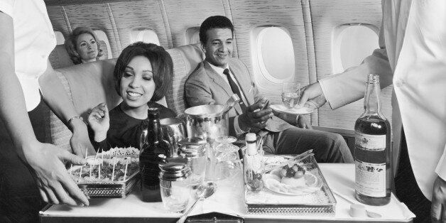 circa 1965: Flight crew serving food and beverages to passengers aboard an airplane, 1960s. (Photo by R. Gates/Hulton Archive/Getty Images)