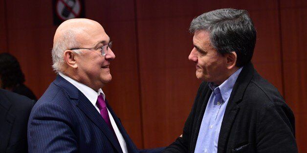 French Finance Minister Michel Sapin (L) and Greece's Finance Minister Euclid Tsakalotos speak together ahead of a Eurogroup finance ministers meeting at the European Council in Brussels, on December 5, 2016. / AFP / EMMANUEL DUNAND (Photo credit should read EMMANUEL DUNAND/AFP/Getty Images)