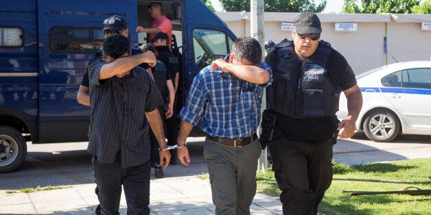 Two of the eight Turkish soldiers who fled to Greece in a helicopter and requested political asylum after a failed military coup against the government, are brought to prosecutor by two policemen in the northern Greek city of Alexandroupolis, Greece, July 17, 2016. REUTERS/Vasilis Ververidis/Eurokinissi GREECE OUT. NO COMMERCIAL OR EDITORIAL SALES IN GREECE
