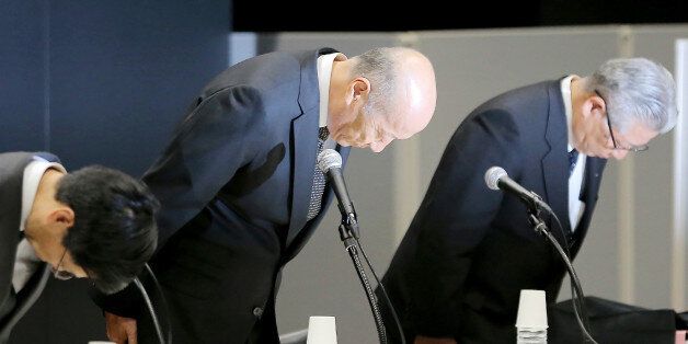 This photo taken on December 28, 2016 shows Tadashi Ishii (C), president of Japan's biggest advertising agency Dentsu, bowing with other excutives during a press conference in Tokyo.Ishii said late on December 28 he plans to step down, a year after the suicide of a young employee that has been linked to allegations of extreme overwork at the company. / AFP / JIJI PRESS / STR / Japan OUT (Photo credit should read STR/AFP/Getty Images)