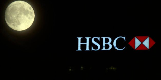 The moon rises over the HSBC building in the Canary Wharf financial district of London, a day before the