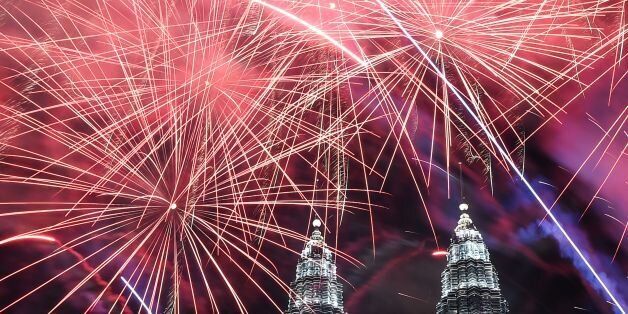 Fireworks illuminate the sky near Malaysia's Petronas Twin Towers during New Year celebrations in Kuala Lumpur on January 1, 2017. / AFP / MOHD RASFAN (Photo credit should read MOHD RASFAN/AFP/Getty Images)