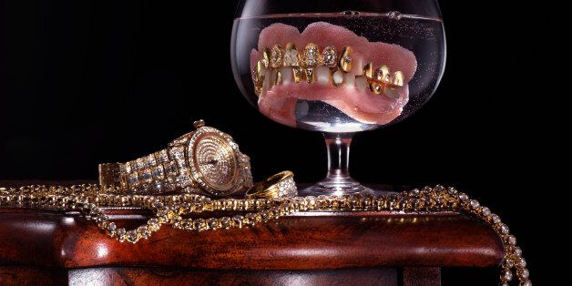 Dentures with precious stones in glass by jewelry and watch