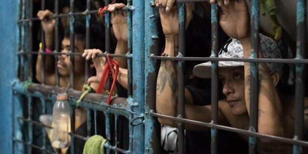 MANILA, PHILIPPINES - DECEMBER 15: Inmates look outside from an overcrowded police jail cell on December 15, 2016 in Manila, Philippines. Philippine president Rodrigo Duterte has said he wanted the Constitution amended to allow Philippine leaders to wield martial law powers without judicial and congressional approval, a move he said is necessary to contain the ongoing 'drug menace' and maintain peace and security in the country. Around 5,882 people have been killed across the country since President Rodrigo Duterte launched his war on illegal drugs five months ago, according to figures from the Philippine National Police. An average of 25 victims were killed daily during the five-month period, and police kill 97 percent of those they shoot, leaving 33 dead for every person wounded according to the figures. Last October, Duterte himself said the country could expect about 20,000 or 30,000 more deaths in his administration's bloody war on drugs. (Photo by Dondi Tawatao/Getty Images)