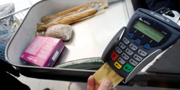 A shopper pays with his credit card in a supermarket in Nice southern France, February 25, 2008 as the country's National Consumer's Institute (INC) reported a raise of food prices between the end of November 2007 and early January 2008. The INC reports that the price of spaghetti increased from between 31% and 45%, yoghurts increased from between 17% and 40% and ham 10% and 44%. REUTERS/Eric Gaillard (FRANCE)