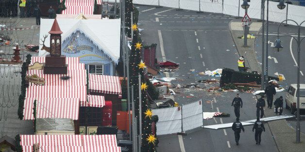 Barriers stand as police officers inspect the scene where a truck drove into a Christmas market in Berlin, Germany, on Tuesday, Dec. 20. 2016. Chancellor Angela Merkel said that German authorities were working on the assumption that the deaths of 12 people after a truck plowed into a Christmas market were a terrorist attack, and pledged to use the full force of German law to bring the perpetrators to justice. Photographer: Jasper Juinen/Bloomberg via Getty Images