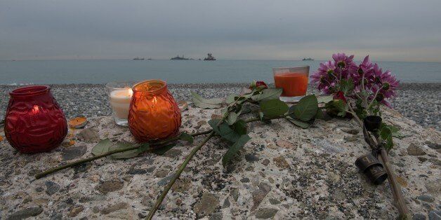 SOCHI, RUSSIA - DECEMBER 27 : Flowers and candles for the victims lay on the beach as ships are seen far behind during the search operation of plane crash near the Black Sea coast of Sochi, Russia on December 27, 2016. A Tupolev Tu-154 plane of the Russian Defense Ministry with 92 people on board crashed into the Black Sea near the city of Sochi on December 25, 2016. The plane was carrying members of the Alexandrov Ensemble, Russian servicemen and journalists to Russia's Hmeymim air base in Syria. (Photo by Ekaterina Lyzlova/Anadolu Agency/Getty Images)