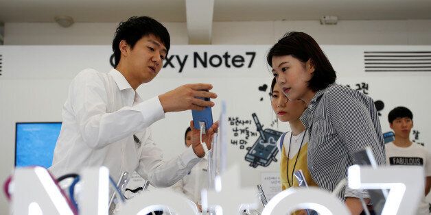 An employee helps customers purchase a Samsung Electronics' Galaxy Note 7 new smartphone at its store in Seoul, South Korea, September 2, 2016. REUTERS/Kim Hong-Ji