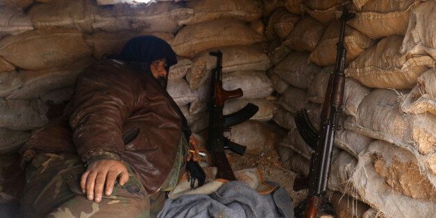 A rebel fighter rests with his weapons behind sandbags at insurgent-held al-Rashideen, Aleppo province, Syria December 30, 2016. REUTERS/Ammar Abdullah
