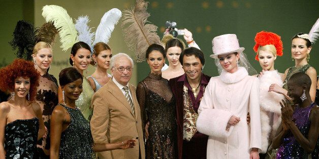 Designers Yildirim Mayruk and Barbaros Sansal are flanked by models presenting creations from their 2004-2005 winter couture. Designers Yildirim Mayruk (center-L) and Barbaros Sansal (center-R) are flanked by models presenting creations from their 2004-2005 winter couture collection during a fashion show named